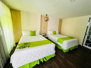 2 camas en una habitación con verde y blanco en Hotel Medrano Temáticas and Business Rooms Aguascalientes en Aguascalientes