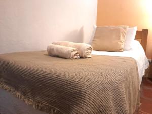 a bed with two towels sitting on top of it at Casa Calma in Colonia del Sacramento