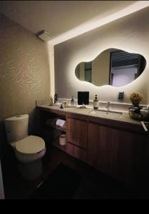 a bathroom with a sink and a toilet and a mirror at Depa Teo in Querétaro +7 photos