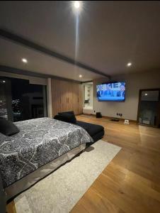 a bedroom with a bed and a flat screen tv at Depa Teo in Querétaro