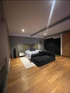 a bedroom with a bed and a couch at Depa Teo in Querétaro
