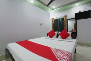 a bedroom with a large bed with red pillows at OYO Flagship 67063 Roy Villa Resort in Baharampur