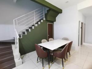 a dining room with a table and chairs and a staircase at 2Houses with A Huge Private Pool 8 Bedrooms & 8 Bathrooms in Kuah