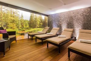 une salle d'attente avec plusieurs chaises et une grande fenêtre dans l'établissement Hotel Garni Edelweiss, à Lech am Arlberg