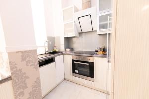 a kitchen with white cabinets and a sink at Danube Dwelling Hercegprimas 2 in Budapest