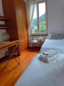 um quarto com 2 camas e uma janela em Large Apartment (3 bedrooms - 2 bathrooms), 50 meters from the beach em Paraggi