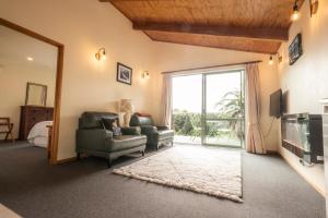 a living room with a couch and a chair and a television at Goldfield Suites in Greymouth