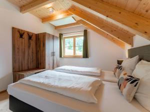 2 bedden in een slaapkamer met houten plafonds bij Chalet Amsel in Donnersbachwald