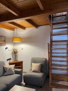 sala de estar con 2 sillas y escalera en Mamá Mila, en Briviesca