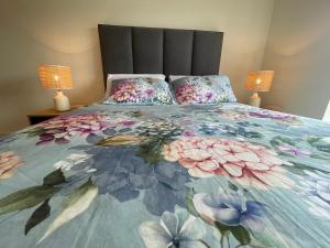 1 cama con edredón de flores y 2 lámparas en Luxury King Size Bed Sandyford Mountain View en Sandyford