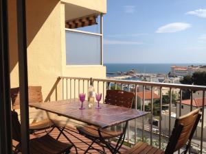 a table with two wine glasses on a balcony at Appartement Miramar in Banyuls-sur-Mer