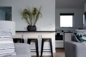 eine Küche mit einer Couch und zwei Hockern und einer Theke in der Unterkunft Kings Cottage in Cambridge