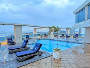 巴拿馬城的住宿－Yc l Habitacion av Balboa - GB701-B，酒店游泳池设有椅子和棕榈树