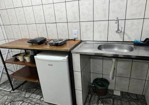 a kitchen with a counter and a sink and a refrigerator at Residencial Margarida APART 5 in Presidente Figueiredo