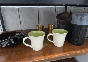 three coffee mugs sitting on a wooden table at Residencial Margarida APART 5 in Presidente Figueiredo