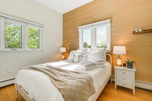 a bedroom with a large bed and two windows at Elegant Gloucester Beach Getaway with Ocean Views! in Gloucester