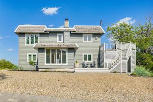 a gray house with a staircase in front of it at Elegant Gloucester Beach Getaway with Ocean Views! in Gloucester
