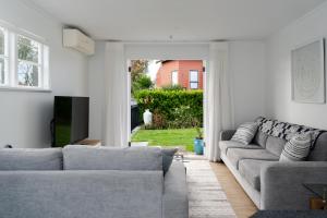 ein Wohnzimmer mit zwei Sofas und einem Fernseher in der Unterkunft Kings Cottage in Cambridge