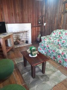 uma sala de estar com um sofá e uma mesa de centro em Sítio pousada e Refúgio lazer e eventos em Santana do Livramento