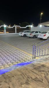 un grupo de autos estacionados en un estacionamiento por la noche en ALSEEB VIEW Serviced Hotel Suites, en Raʼs al Khafjī