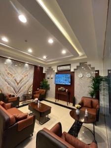 vestíbulo con sofás y TV de pantalla plana en ALSEEB VIEW Serviced Hotel Suites, en Raʼs al Khafjī