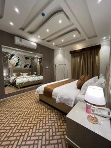 Habitación de hotel con cama y escritorio con lámpara. en ALSEEB VIEW Serviced Hotel Suites, en Raʼs al Khafjī