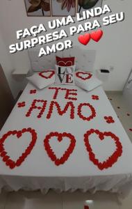 a bed with hearts on it with the words fiesta una luna inn at Pousada Jeitim Mineiro in Capitólio