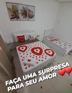 a room with a bed with red hearts on it at Pousada Jeitim Mineiro in Capitólio