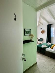 Citroom - green city rooms في أولبيا: باب يؤدي الى غرفة نوم بسرير