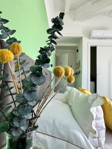 a vase with flowers on a table in a room at Citroom - green city rooms in Olbia +56 photos