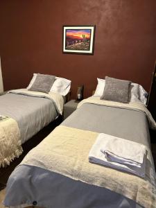 a room with two beds and a picture on the wall at Casa en el corazón de Huacalera, Jujuy in Tilcara