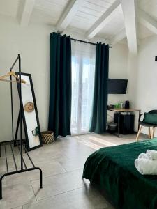 una camera da letto con tende verdi, un letto e uno specchio di Citroom - green city rooms a Olbia