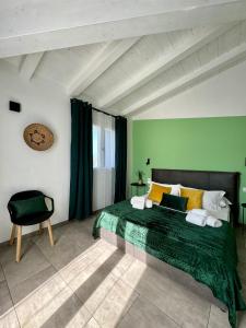 una camera verde con un letto e una sedia di Citroom - green city rooms a Olbia
