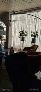 a room with chairs and a window with white curtains at Hotel Alnacir in Faro +191 photos