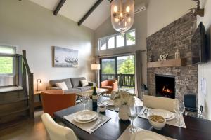 a living room with a table and a fireplace at Stunning Condo - View on Lake Tremblant & Mountain in Mont-Tremblant
