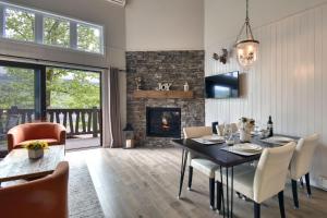 a dining room with a table and a fireplace at Stunning Condo - View on Lake Tremblant & Mountain in Mont-Tremblant