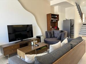 a living room with a couch and a tv at Chau's House Novaworld Phan Thiet in Bình Tú