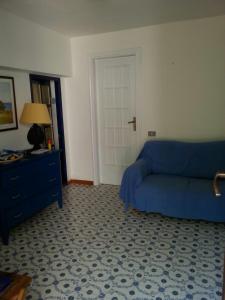 a living room with a blue couch and a door at Villa la Ficuzza in Cittadella del Capo