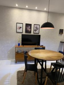 a dining room with a table and chairs and a tv at Blue House Casa de temporada no brejo in Solânea +28 photos