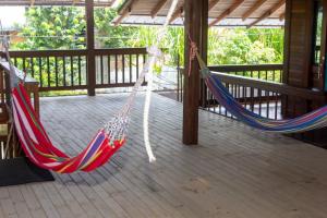 two hammocks on a deck with a porch at Eco Hotel La Canita in Nuquí