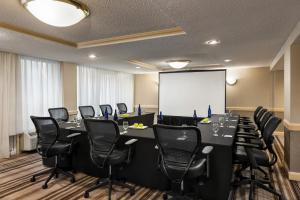 a conference room with a long table and black chairs at Holiday Inn Gaithersburg by IHG in Gaithersburg