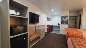 a hotel room with two beds and a flat screen tv at Presidio Parkway Inn in San Francisco