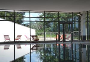 - un groupe de chaises assises à côté de la piscine dans l'établissement VTF Les Fougères, à Soultzeren