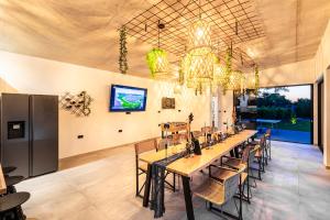 a dining room with a long table and chairs at Jackal Holiday House with a heated pool and a jacuzzi in Lovreć