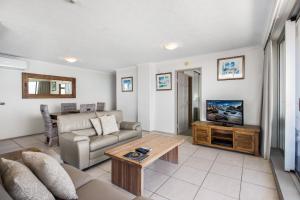 sala de estar con sofá y TV en Boulevard Towers on Broadbeach, en Gold Coast