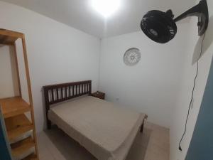 a bedroom with a bed and a light on the wall at Casa Feliz em Gravatá - A 100 metros do Pátio de Eventos in Gravatá +6 photos