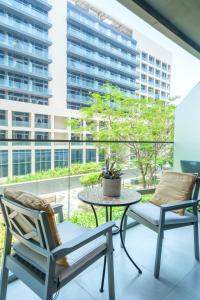 two chairs and a table on a balcony with a building at Saadiyat Serene Studio in Abu Dhabi