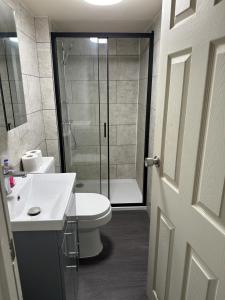 a bathroom with a shower and a toilet and a sink at ELSARO guest house in Slough