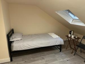 a bed in a room with a skylight at ELSARO guest house in Slough