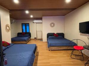 Habitación con 2 camas y TV de pantalla plana. en Mộc Homestay, en Mộc Châu